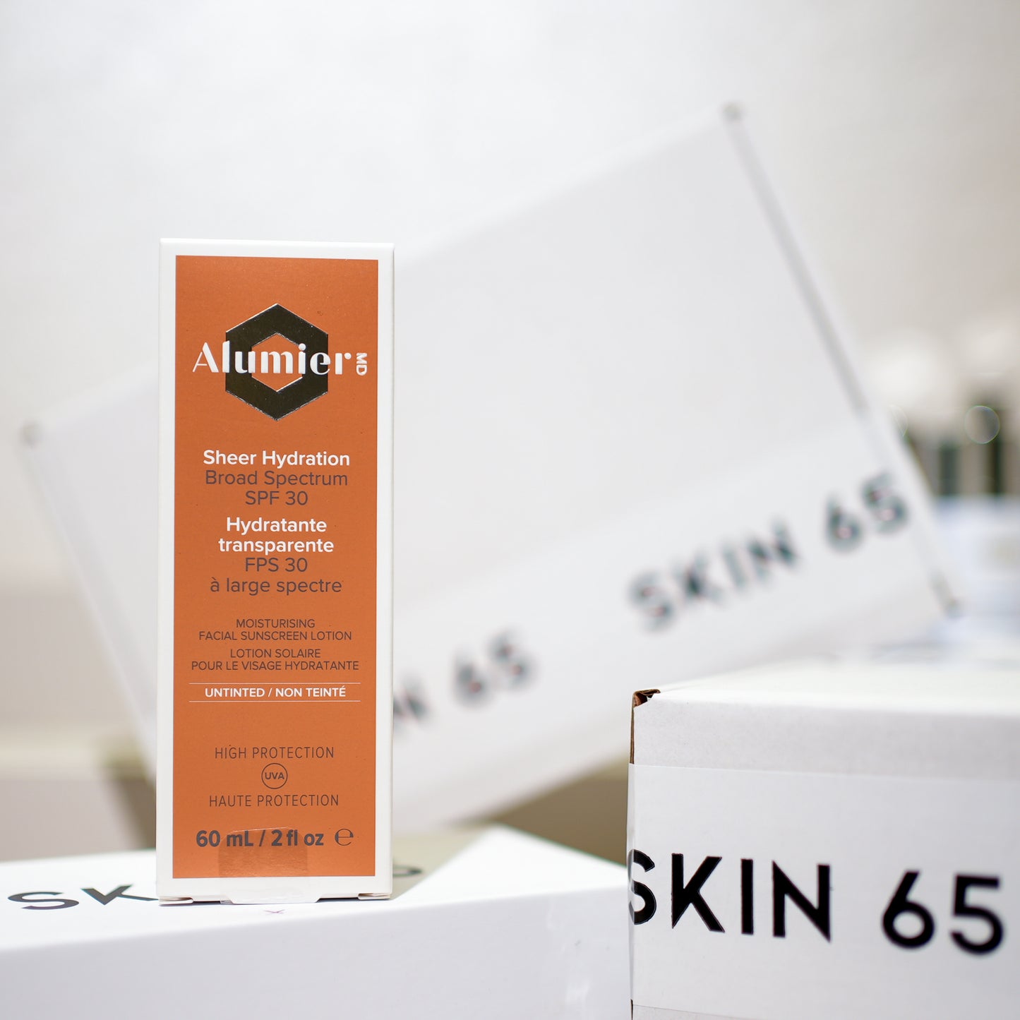 Alumier MD Sheer Hydration Broad Spectrum SPF 30 (Untinted) in the box with Skin65 Branding in the Background