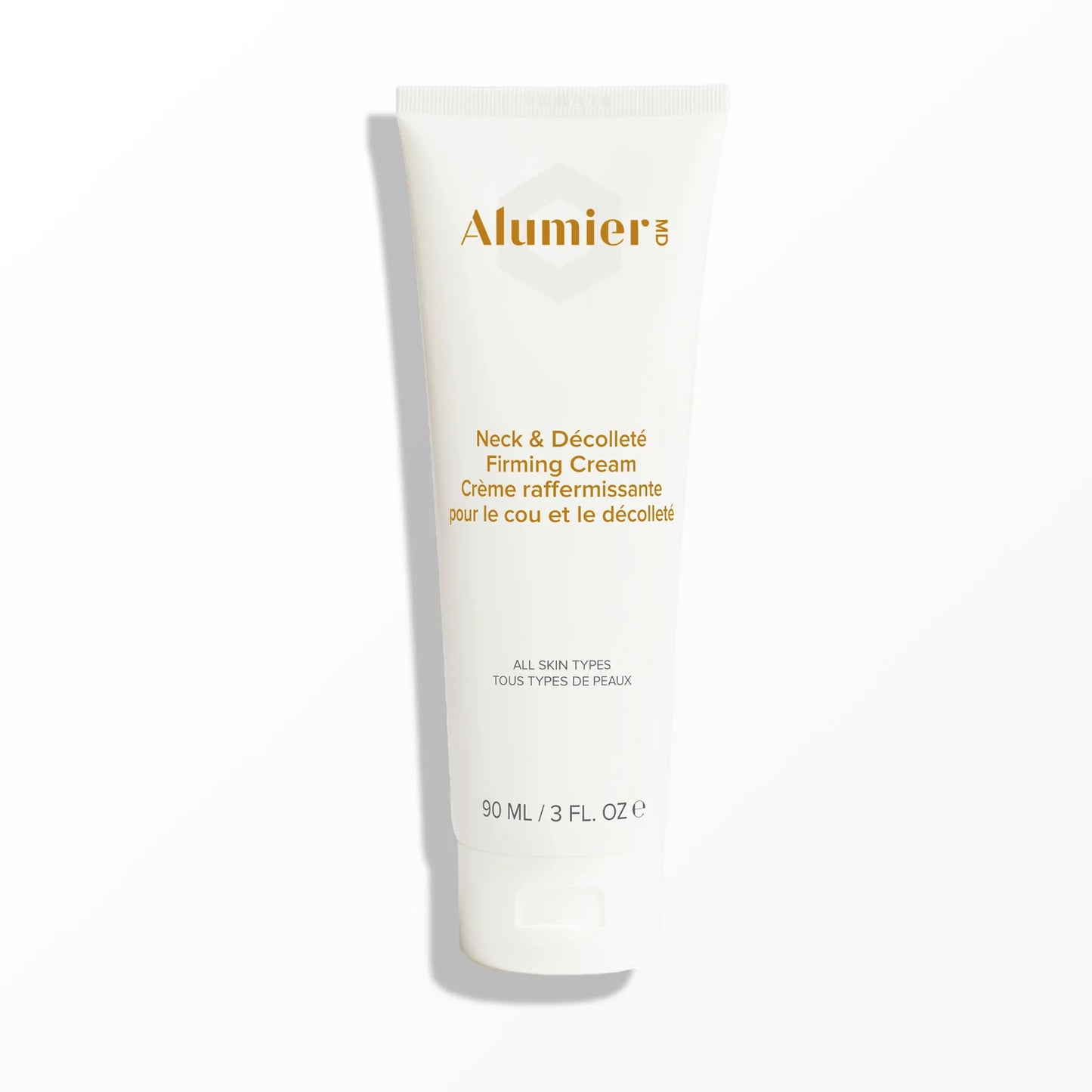 White tube of "Alumier MD Neck & Décolleté Firming Cream" stands upright on a clean, light background. Text reads: "All skin types, 90 mL / 3 fl. oz," and is written in English and French.