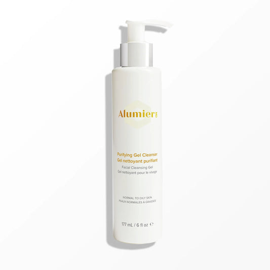 White cylindrical pump bottle labeled "Alumier Purifying Gel Cleanser, Facial Cleansing Gel, Normal to Oily Skin, 177 mL / 6 fl oz" stands in a minimalistic, light-colored setting.