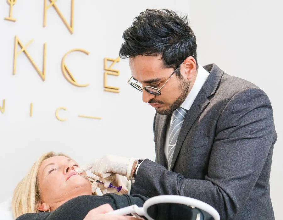 A doctor administers an injection to a patient’s face with precision in a modern clinic. Text in the background partially reads "Skin Science Clinic."