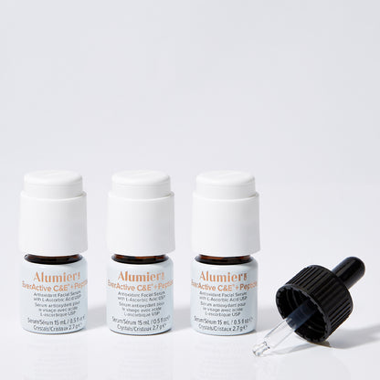 Three small brown bottles labeled "Alumier EverActive C&E™ + Peptide" with white caps stand in a row, accompanied by a black dropper, set against a white background.