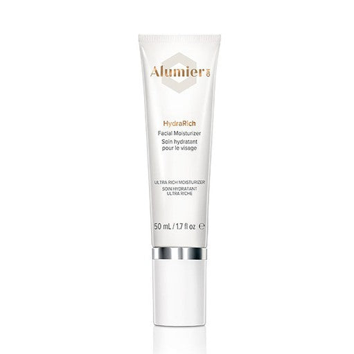 A white tube labeled "Alumier MD HydraRich Facial Moisturizer" stands upright against a plain backdrop. The text reads: "ULTRA-RICH MOISTURIZER, 50 mL / 1.7 fl oz."