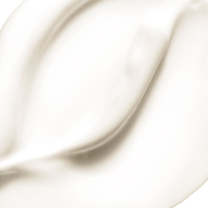 Creamy white substance is spread smoothly, displaying gentle curves and peaks with a glossy texture, resembling lotion or whipped cream.