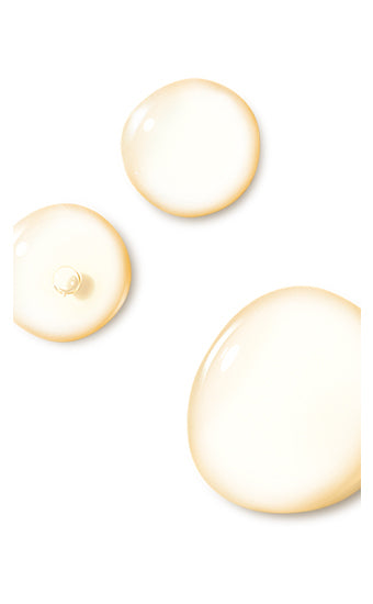 Translucent liquid droplets are randomly placed on a plain white background, varying in size and suggesting a viscous consistency.