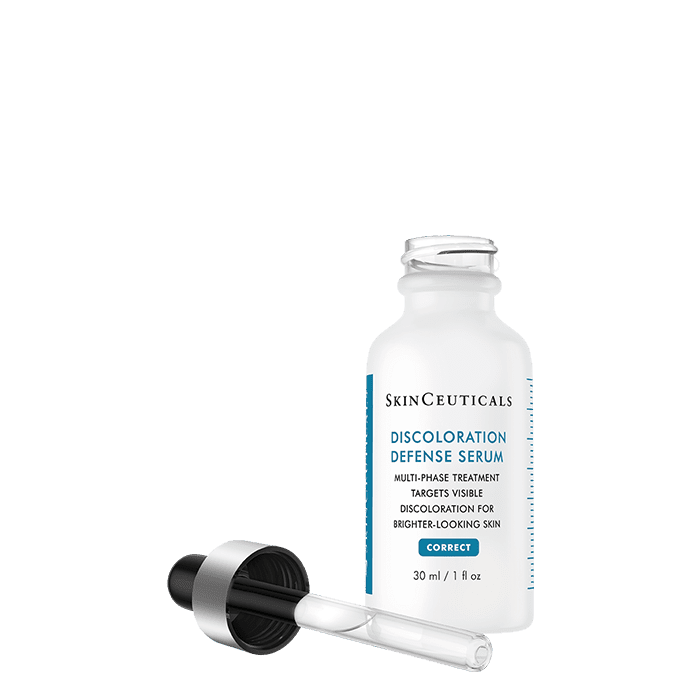 A white bottle labeled "SkinCeuticals Discoloration Defense Serum" with its dropper cap removed, resting on its side, on a plain white surface. The bottle contains 30 ml (1 fl oz) of serum.